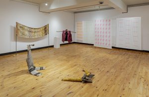 an installation view of the exhibition Homecoming, featuring various textile artworks