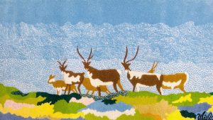a textile depicting a group of six deer in a multicoloured landscape under a blue and white sky